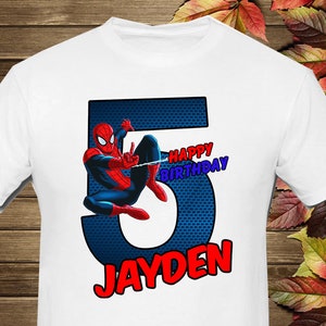 May include: White t-shirt with a red and blue number 5. Spiderman is swinging from a web in front of the number. The text "Happy Birthday" is above the number and "JAYDEN" is below the number.
