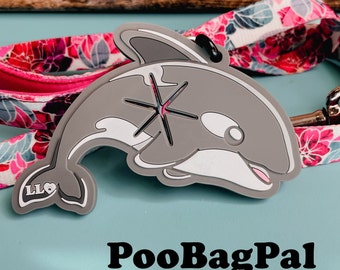 Puede incluir: Porta bolsas de excrementos para perros de silicona gris en forma de delfín con un recorte de estrella blanca y el texto "PooBagPal" impreso debajo.