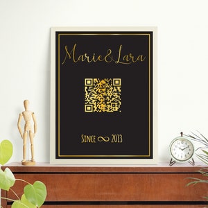 Könnte beinhalten: Ein schwarzer und goldfarbener gerahmter Druck mit dem Text "Marie & Lara" in goldener Schrift, einem goldenen QR-Code und dem Text "Since ∞ 2013" in Gold.