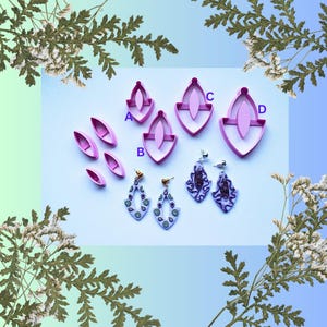 Puede incluir: Imagen que muestra cortadores de pendientes de arcilla polimérica rosa y pendientes terminados. Los cortadores tienen varias formas, incluyendo diseños de lágrima y pétalo. También se muestran dos pares de pendientes terminados con patrones intrincados y hallazgos dorados.