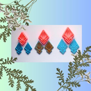 Peut inclure: Plusieurs paires de boucles d'oreilles géométriques aux couleurs vives. Les boucles d'oreilles sont présentées par paires, avec des variations de rouge, de bleu et d'or. Le design est angulaire et comporte des détails décoratifs.