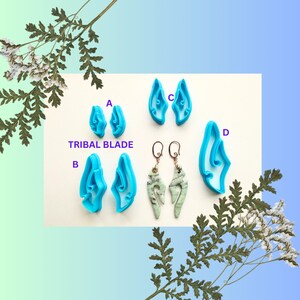 Peut inclure: Quatre paires de boucles d'oreilles en plastique bleu en forme de flamme stylisée. Les boucles d'oreilles sont étiquetées A, B, C et D. Les boucles d'oreilles étiquetées A et B sont plus petites que les boucles d'oreilles étiquetées C et D. Les boucles d'oreilles étiquetées C et D sont plus grandes et ont un design plus complexe. Les boucles d'oreilles étiquetées C et D sont également étiquetées "Tribal Blade".