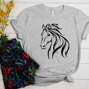 Peut inclure: Un t-shirt gris avec une silhouette noire de t&ecirc;te de cheval sur le devant.
