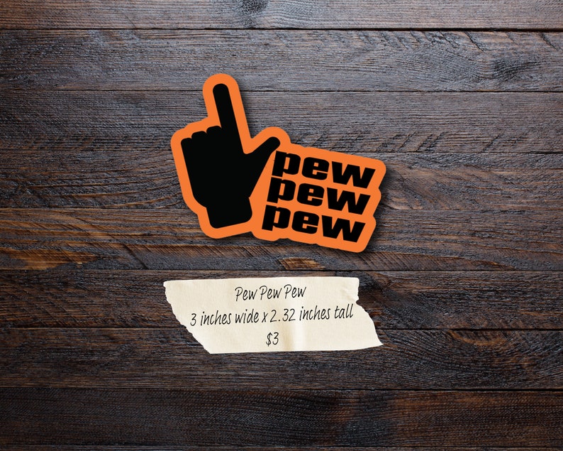 Puede incluir: Pegatina naranja con una mano negra apuntando hacia arriba y las palabras "pew pew pew" en negro. La pegatina mide 7,62 cm de ancho y 5,9 cm de alto.
