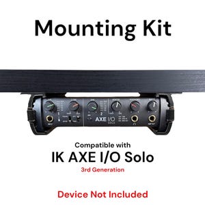 May include: Black mounting kit for an IK Multimedia AXE I/O Solo audio interface. The kit includes a metal bracket and screws for mounting the interface to a desk or shelf. The text "Compatible with IK AXE I/O Solo 3rd Generation" and "Device Not Included" is printed below the interface.