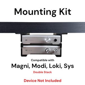 May include: A black mounting kit for two audio devices, compatible with Magni, Modi, Loki, and Sys. The kit is shown mounted to a black surface. The text "Double Stack" and "Device Not Included" is also shown.