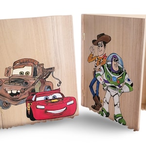 May include: Wooden bookends featuring cartoon characters from the movies Cars and Toy Story. One bookend has Mater and Lightning McQueen. The other has Woody and Buzz Lightyear. The bookends are made of light-colored wood.