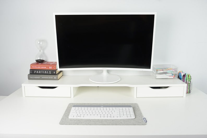 Smallest size (18 x 11 inch) desk mat in light grey color. Desk mat is mostly filled up by white keyboard with white mouse sitting off of the desk mat.