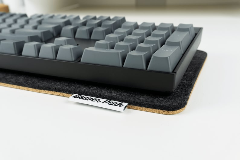 Mechanical keyboard on top of black felt desk mat -full size Keychron K10 keyboard.