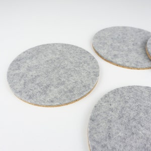 A set of 4 of our circle coasters shown up close in light grey merino wool felt.