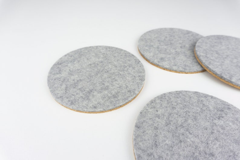 A set of 4 of our circle coasters shown up close in light grey merino wool felt.