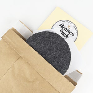 Recyclable packaging for our wool coasters shown up close. We ship each set of coasters out in a recycled paper mailer.