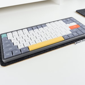 Nuphy Air 75% keyboard on black wool felt keyboard mat against white desk.