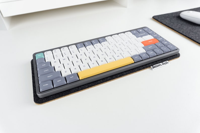 Nuphy Air 75% keyboard on black wool felt keyboard mat against white desk.