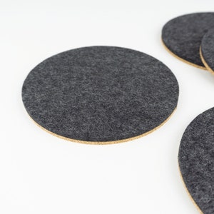 A set of 4 of our circle coasters shown up close in black merino wool felt.