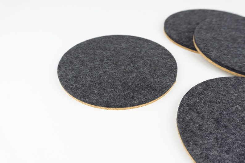 A set of 4 of our circle coasters shown up close in black merino wool felt.