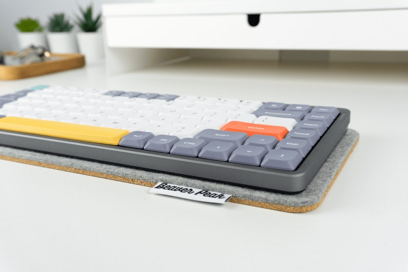 Grey wool felt keyboard mat on desk with Nuphy Air75 mechanical keyboard on top.