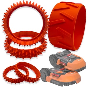 May include: A collection of bright orange robotic lawn mower wheel attachments, including two large spiked rings, one wide treaded band, and two smaller spiked rings, displayed alongside two orange and gray robotic lawn mowers with Cut to Edge text.