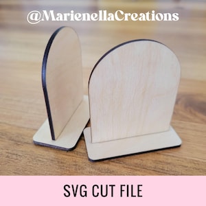 May include: Two unfinished wooden signs with rounded tops and a flat base. The signs are made of light wood and have a dark brown border. The signs are perfect for crafting and personalization.  @MarienellaCreations SVG CUT FILE