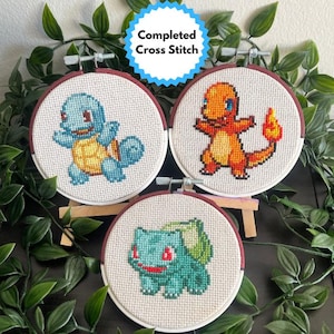 Decoración de punto de cruz terminada: Pokémon inicial con aro pintado a mano.