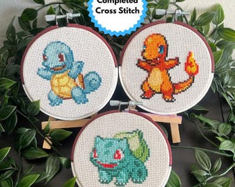 Decoración de punto de cruz terminada: Pokémon inicial con aro pintado a mano.