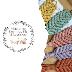 May include: A macramé keyrings kit with five keyrings in shades of yellow, green, pink, purple, and orange. Each keyring has a textured, woven design and a metal clasp. The image also includes a colour palette and a logo that reads "Macrame Keyrings Kit (5 keyrings) Raybeam makes."