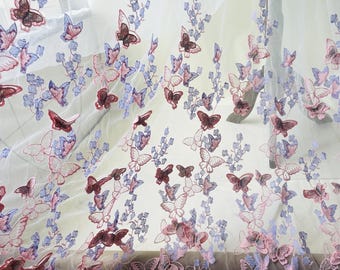 May include: Delicate white fabric featuring embroidered butterflies and floral motifs. The butterflies are in burgundy, pink, and lavender hues, with intricate detailing. The floral elements are in lavender and blue.