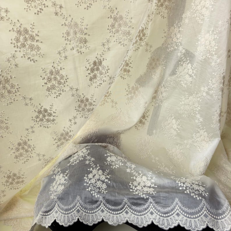 Pu&ograve; includere: Tessuto bianco sporco con un delicato motivo floreale. Il tessuto &egrave; trasparente, con fiori ricamati in una tonalit&agrave; pi&ugrave; chiara. Un bordo in pizzo smerlato con un motivo floreale &egrave; visibile, aggiungendo un tocco di eleganza.