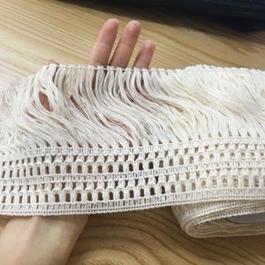 Può includere: Passamaneria con frange color crema con un design traforato tessuto. La passamaneria presenta lunghe frange fluenti nella parte superiore e una base a motivi. Questa passamaneria decorativa è adatta a vari progetti di artigianato e cucito.