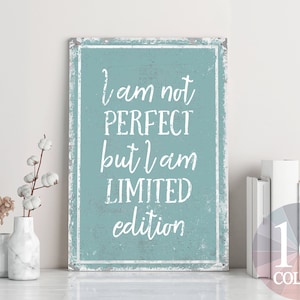Könnte beinhalten: Ein hellblaues Schild mit weißem Text, der "Ich bin nicht perfekt, aber ich bin limitierte Auflage" lautet. Das Schild hat einen abgenutzten, Vintage-Look.