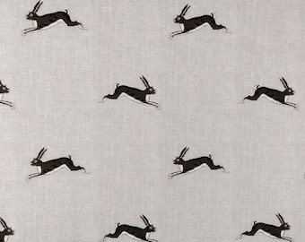 Pode incluir: Um tecido cinza claro com um padrão repetido de lebres a correr. As lebres são castanhas escuras com detalhes brancos. Ideal para têxteis ou decoração de casa.