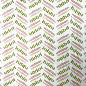 Puede incluir: Primer plano de una tela blanca con un patrón repetido de líneas diagonales. Las líneas alternan entre rosa claro y verde oliva, creando un efecto de textura de pincelada. El diseño recuerda a un patrón de espiga.