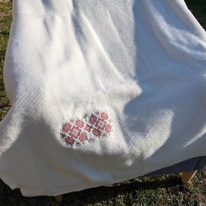 Sie können diese Babydecke personalisieren lassen, bestickt bereits aus reiner Lammwolle mit den Worten „Rote Kugeln „39.37“. (100/150cm). Schreiben Sie Text auf die Decke.