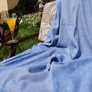 Sie können die blaue Baumwolldecke - einfarbig - 150/200 cm personalisieren. Schreiben Sie Text auf die Decke mit Fäden.