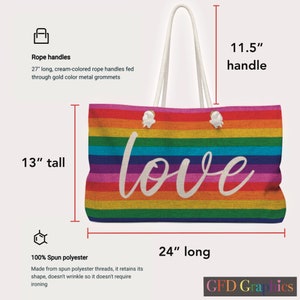 Op de afbeelding: Een regenboog gestreepte tote bag met witte touw handvatten en het woord "love" in wit schrift. De tas is 61 cm lang, 33 cm hoog en de handvatten zijn 29 cm lang. De tas is gemaakt van 100% gesponnen polyester.