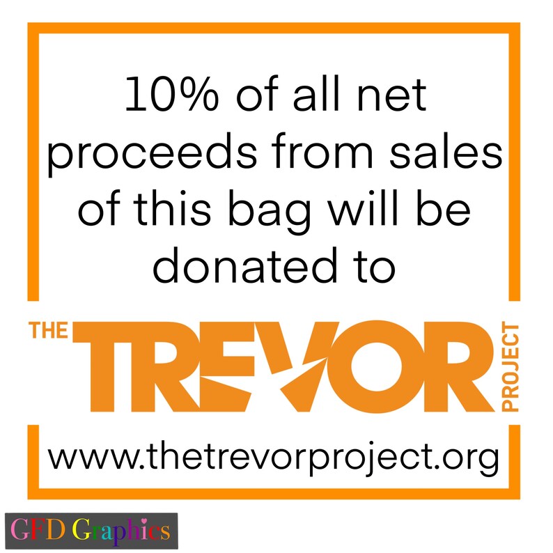 Op de afbeelding: Oranje en witte afbeelding met de tekst "10% van alle netto-opbrengsten van de verkoop van deze tas wordt gedoneerd aan THE TREVOR PROJECT www.thetrevorproject.org"