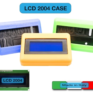 Op de afbeelding: Drie plastic behuizingen voor een LCD 2004 display. De behuizingen zijn blauw, groen en oranje. Het display is zichtbaar in de oranje behuizing. Het display is gelabeld met "LCD 2004".