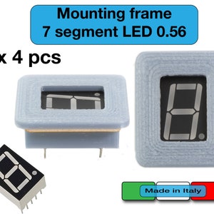 Puede incluir: Cuatro pantallas LED de 7 segmentos de 0,56 pulgadas con marcos de montaje. Las pantallas son grises y los marcos son blancos. El texto "Marco de montaje LED de 7 segmentos 0,56 x 4 uds Hecho en Italia" es visible en la imagen.