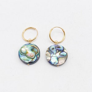 May include: A pair of gold hoop earrings with a blue and green abalone shell pendant on each earring.