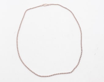 May include: A silver rope chain necklace with a lobster clasp.