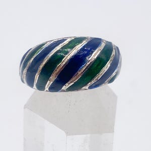 Puede incluir: Un anillo de plata con un dise&ntilde;o de esmalte colorido. El anillo presenta rayas alternas de esmalte azul y verde, creando un patr&oacute;n llamativo. Una pieza de joyer&iacute;a llamativa.