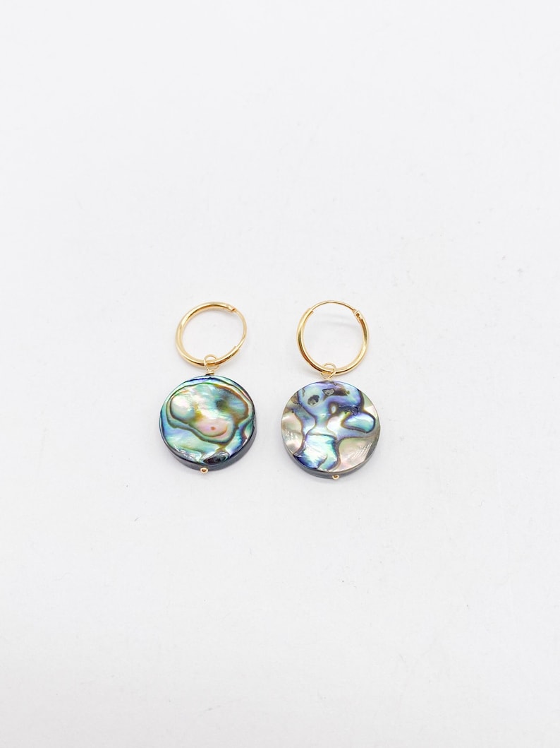 May include: A pair of gold hoop earrings with a blue and green abalone shell pendant on each earring.