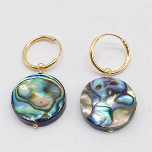 May include: A pair of gold hoop earrings with a round iridescent abalone shell pendant on each earring.