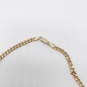 May include: A gold chain necklace with a lobster clasp closure.