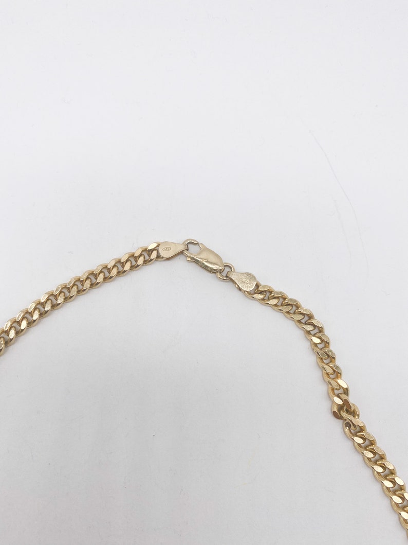 May include: A gold chain necklace with a lobster clasp closure.