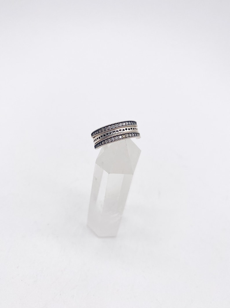 May include: A silver ring with two rows of small, clear stones set in a delicate design.