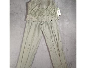 Puede incluir: Un conjunto de dos piezas en color verde salvia que consta de una blusa sin mangas y pantalones a juego. La blusa presenta rayas metálicas verticales y una banda horizontal de patrones de hojas bordadas. Incluye una etiqueta blanca.