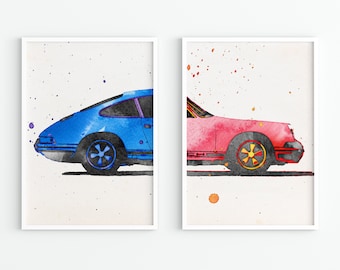 Puede incluir: Dos impresiones en acuarela enmarcadas de coches clásicos. Un coche es azul con un marco de ventana púrpura, el otro es rosa con acentos amarillos y rojos. Ambos tienen ruedas negras y están sobre un fondo blanco con salpicaduras de pintura.