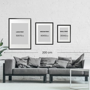 May include: Three black framed prints with white mats and text. The prints are labeled "Large Print 50x70cm", "Medium Print 40x50cm", and "Small Print 30x40cm". A measuring tape shows the distance between the two outer frames is 200 cm.