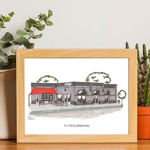 May include: A framed illustration of a building with a red awning and the text "Flyteco Brewing". The building is drawn in black and white with a gray roof and windows. The illustration is on a white background.
